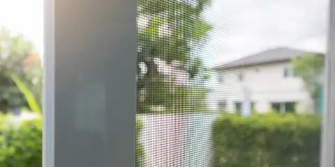 Insektenschutz-Spannrahmen am Fenster mit Blick in den Garten