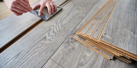 Handwerker verlegt Laminatboden – präziser Innenausbau von Tischlermeister Jan Flieger