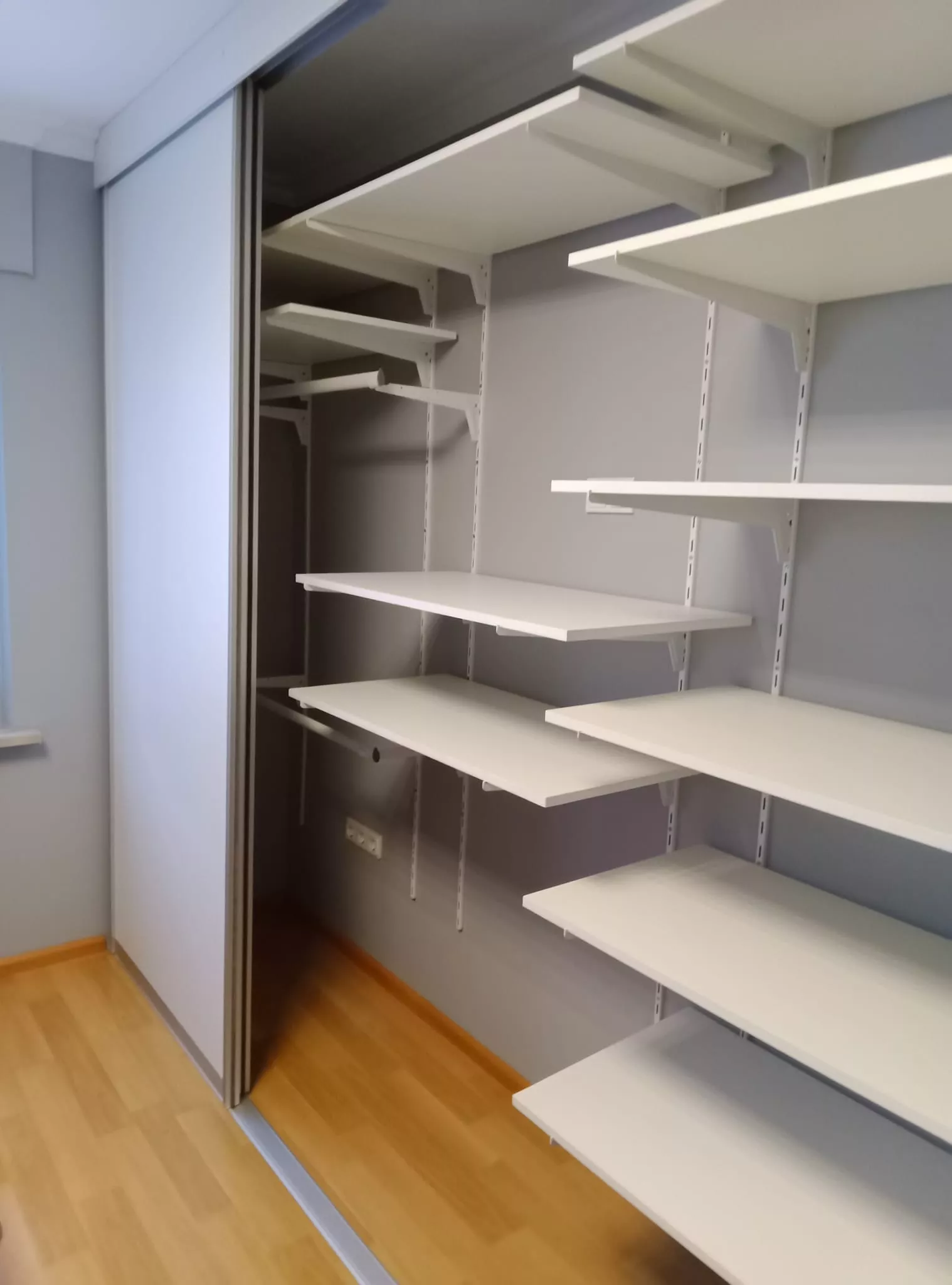 Offener Einbauschrank mit weißen Regalböden und Schiebetüren – individuelle Schreinerarbeit