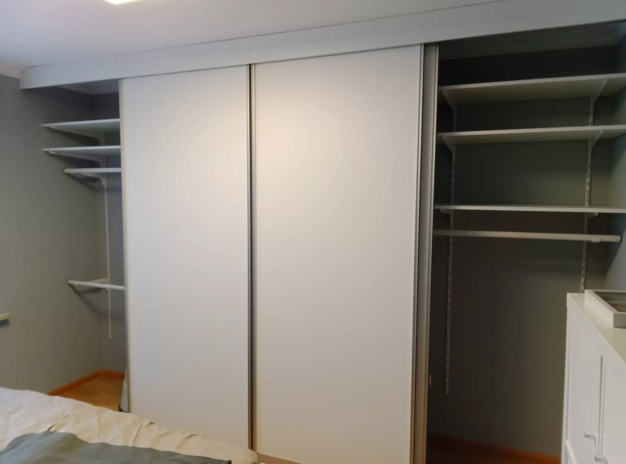 Ein auf Maß eingebauter weißer Schiebetürenschrank